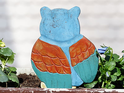 blue and orange wooden bird decor beside plants thumbnail