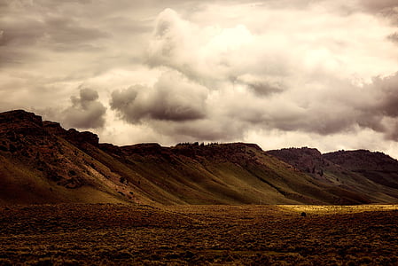grass covered mountain under white cloudy sky thumbnail