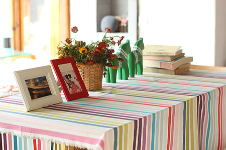 two photo frames beside flower arrangement on table thumbnail