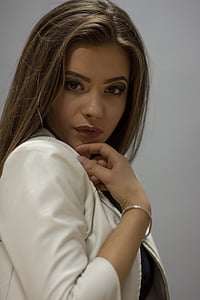 woman wearing white blazer standing near white wall thumbnail