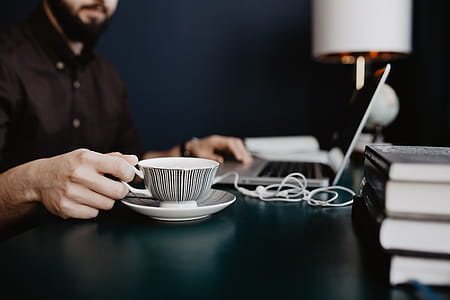 Male working with a laptop and a cup of coffee thumbnail