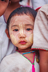 close up photo of boy with yellow paint on face thumbnail