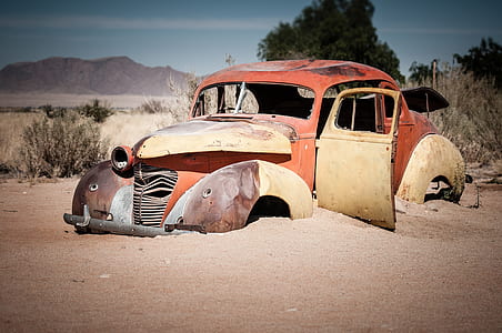photo of vintage red car on brown sand thumbnail
