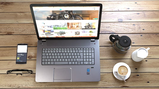 Silver Laptop Next to Coffe Cup Smartphone and Glasses thumbnail