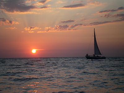 silhouette of sailboat on body of water at sunset thumbnail