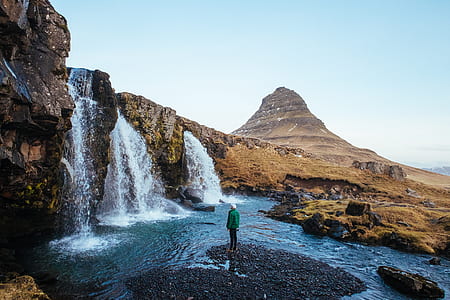 man standing on heart-shaped ground near waterfalls thumbnail