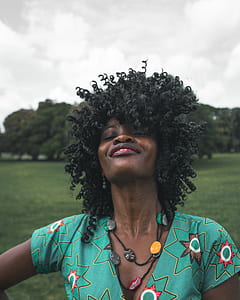 woman wearing green and multicolored V-neck shirt posing for photo thumbnail