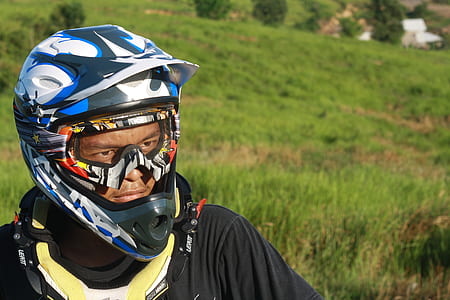 Man Wearing White Blue and Black Motorcycle Helmet during Daytime thumbnail