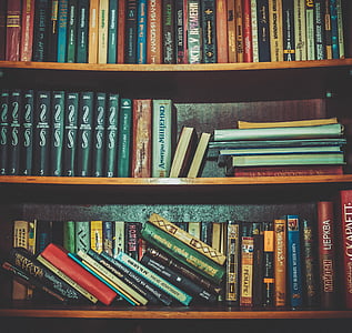 assorted book lot on brown wooden tiered shelf thumbnail