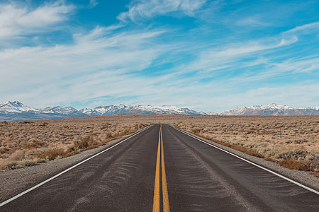 gray road top surrounded with brown bushes under blue sky and white clouds at daytime thumbnail