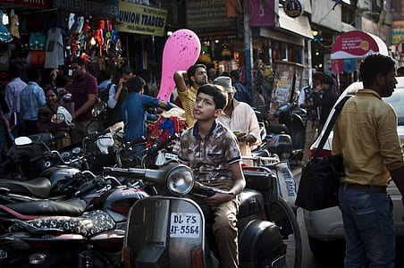 boy sitting on gray motor scooter at alley thumbnail