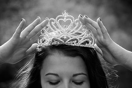 woman holding silver-colored crown thumbnail