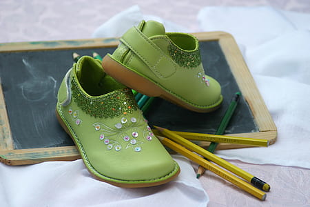 toddler's pair of green leather shoes on black board thumbnail