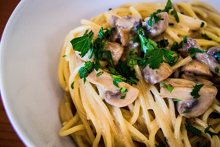 pasta with mushroom and green leafy vegetable toppings in white bowl thumbnail