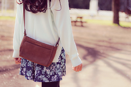tilt shift lens woman in white long sleeve cardigan with brown leather crossbody bag thumbnail