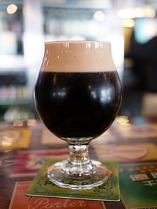 clear footed drinking glass filled with black liquid thumbnail