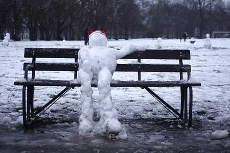 selective focus photography of snowman sitting on bench thumbnail