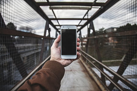 person holding white Android smartphone on bridge thumbnail