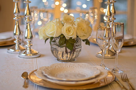 white roses with clear glass champagne flute and white ceramic plate thumbnail