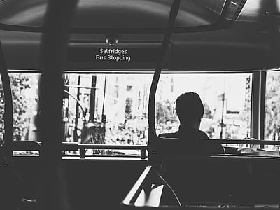 greyscale photography of person sitting on a bus stop thumbnail