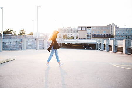 photo of woman walking on street during daytime thumbnail
