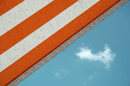 low angle photo of white and orange striped building thumbnail