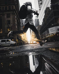 man leaping on water paddle in middle of street thumbnail