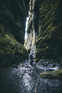 man standing on river water while looking up thumbnail