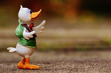 tilt-shift photography of duck wearing green top standing on green surface thumbnail
