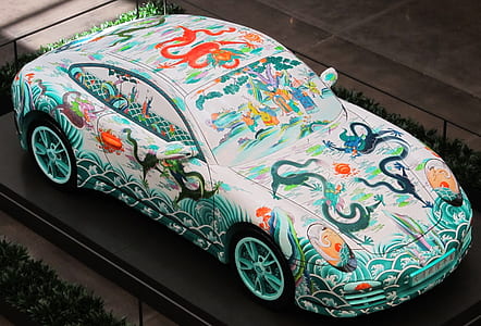 blue and white painted car parked beside green grass thumbnail