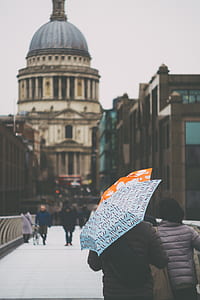 man in bubble jacket holding umbrella thumbnail