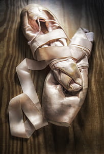 pair of beige leather mittens on the brown wood thumbnail