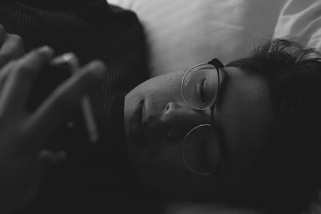 grayscale photo of man wearing eyeglasses holding phone thumbnail