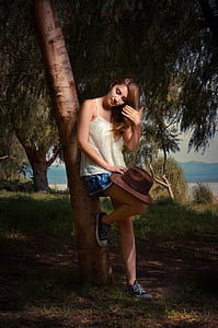 woman in white spaghetti strap with blue skirt leaning on tree thumbnail