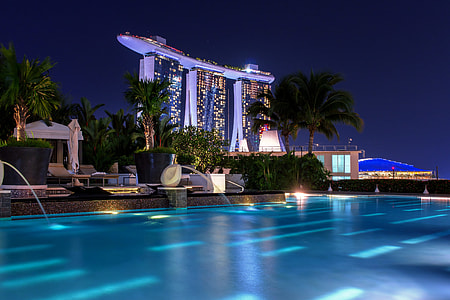 swimming pool near high-rise building during nighttime thumbnail