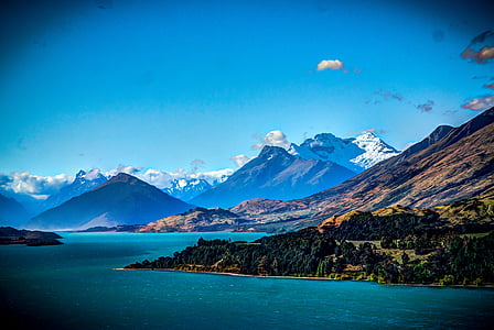 mountain range near water with clouds thumbnail