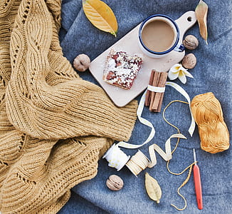 cup of coffee and bread on chopping board near yarn and knit stick thumbnail