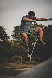 Man Skateboarding Near Trees At Daytime thumbnail