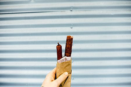 person holding pack of two sausages thumbnail