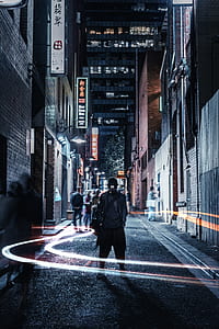 man wearing black jacket on street during nightime thumbnail