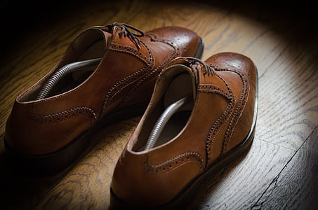 pair of brown leather wingtip Derby shoes on brown parquet floor thumbnail