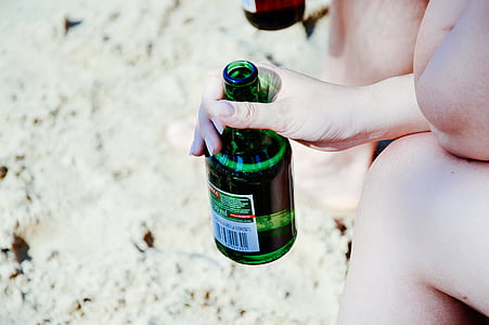 close-up photo of person holding green labeled bottle thumbnail