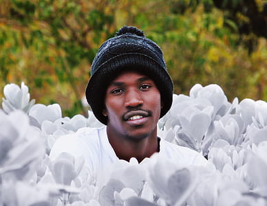 smiling man surrounded by white flowers thumbnail