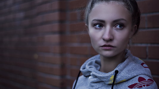 woman on front of red brick wall thumbnail