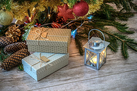 two grey gift boxes beside grey candle lantern and pinecones thumbnail