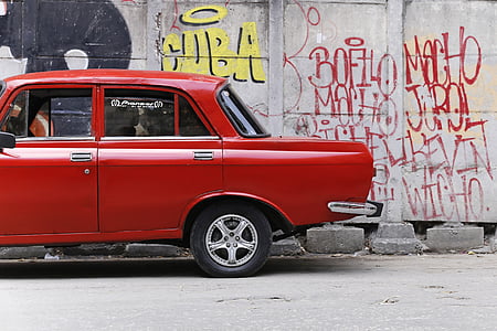 red vehicle parking near white concrete wall thumbnail