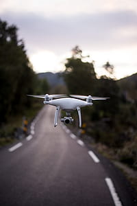 white drone flying on street thumbnail
