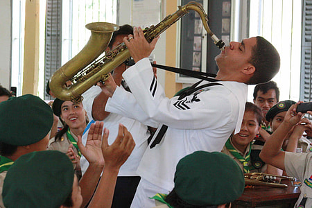 man playing saxophone in front of children thumbnail