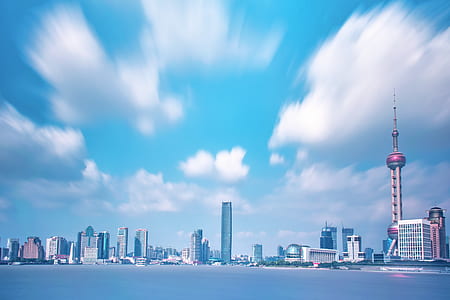 gray concrete buildings under blue sky and white clouds during daytime thumbnail