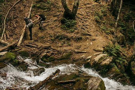 two man hiking on mountain beside water thumbnail